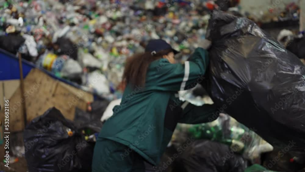 African American woman sorting garbage bags at a recycling plant. Pollution control African American woman sorting garbage bags at a recycling plant. Pollution control