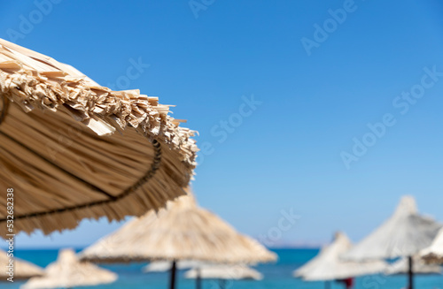 Beach umbrella straw hat overlooking the sea mountain sky, close-up photo