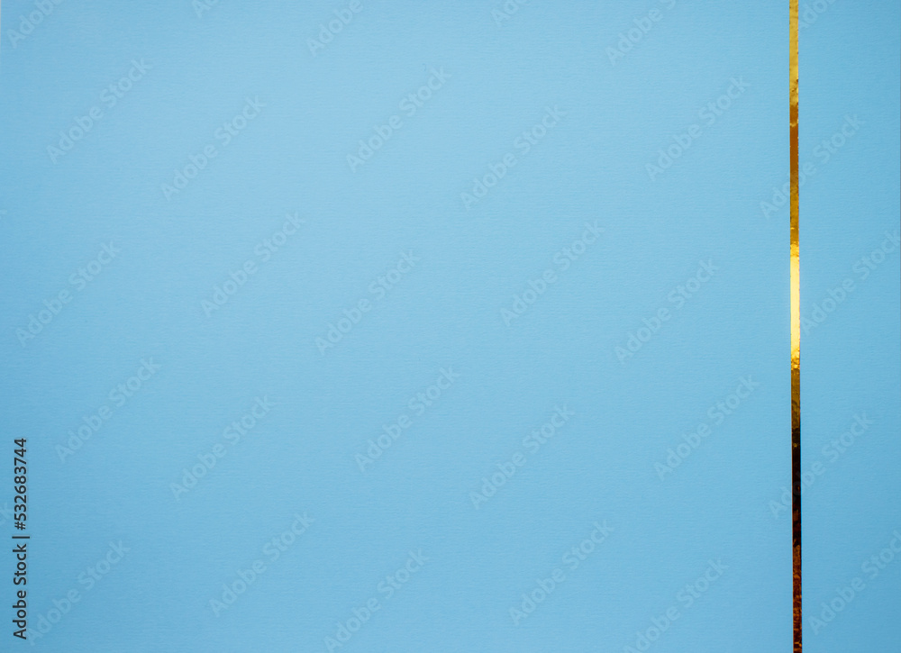 Obraz premium Blue paper background with gold ribbon on the side. Space for inscriptions and text.