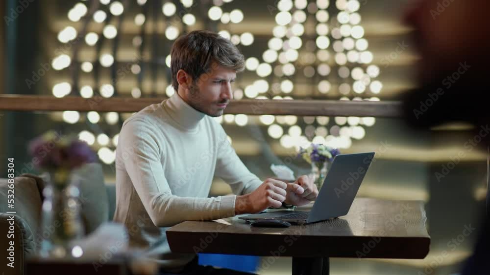 Portrait of a young freelancer working on a laptop, focused man typing on a laptop, remote work in a cafe, the thinking process. Portrait of a young freelancer working on a laptop, focused man typing on a laptop, remote work in a cafe, the thinking process.