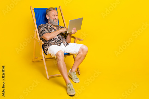 Fotografie, Obraz Full body portrait of handsome man sit lounger hold use netbook coworking isolat