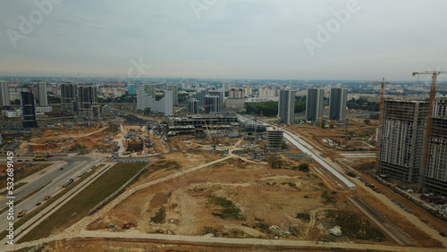 Construction site of a new city block. Construction of multi-storey buildings. Overcast weather. Aerial photography.