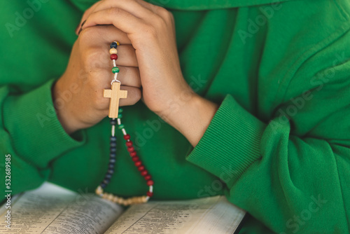 Prayer beads in the hands. 
Mala beads close up. Process of praying and reading the Bibile. photo