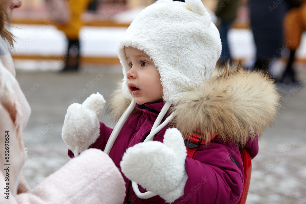 Mother and daughter are walking around the city on Christmas and New Year holidays. Parent and little child having fun outdoors Mother and daughter are walking around the city on Christmas and New Year holidays. Parent and little child having fun outdoors