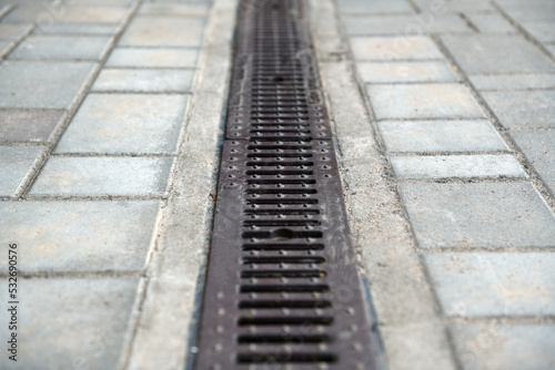 Drainage system with stainless steel composite grating between paving slabs. © lial88