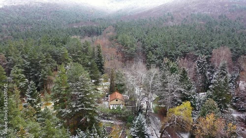  Aerial view little house in snowy forest.  Winter landscape. Stepanavan,  Dendropark  Armenia , Caucasus. Drone fly over trees and fir trees covered snow. Cottage in the winter forest. photo