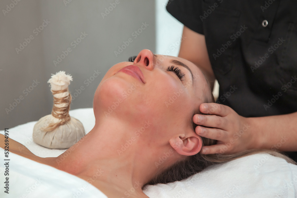 Head massage woman in SPA salon. Massaging therapist makes therapy mass  head for female. Sensual healthy massaging in hands of professional  masseur. Concept of health care and beauty. Copy space Stock Photo