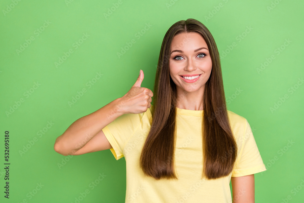 Photo of sweet optimistic satisfied girl with straight hairdo wear yellow t-shirt showing thumb up isolated on green color background Photo of sweet optimistic satisfied girl with straight hairdo wear yellow t-shirt showing thumb up isolated on green color background