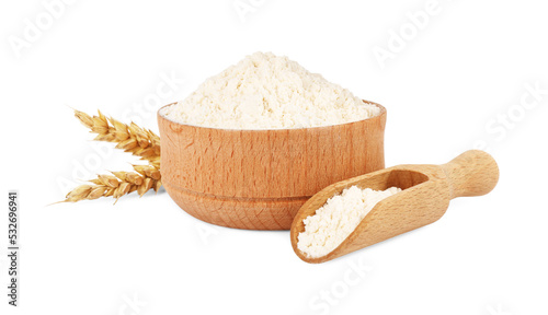 Wooden bowl and scoop with wheat flour isolated on white