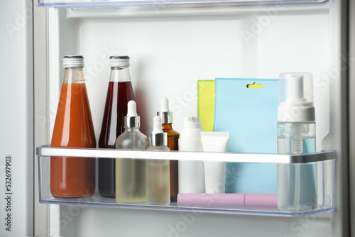 Different cosmetic products on shelf in refrigerator