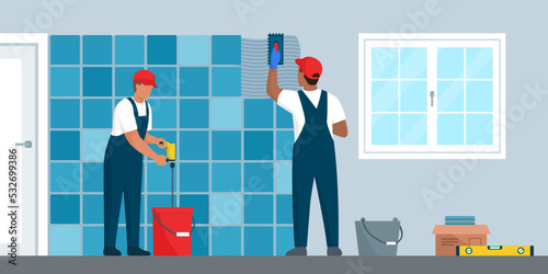 Professional tilers installing tiles on a wall
