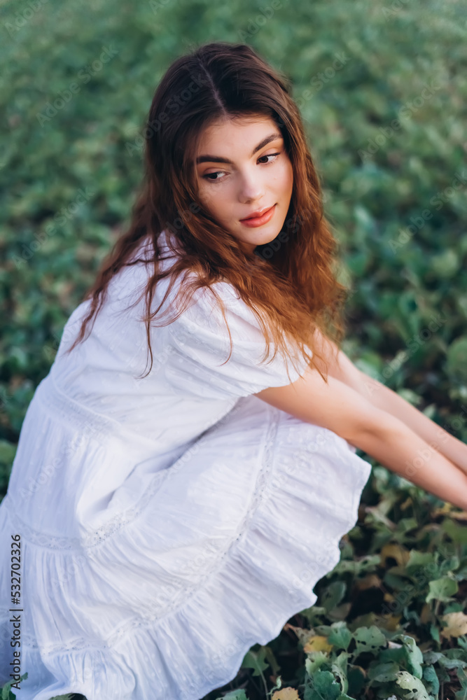 Young girl in white dress in a green meadow. Sensual, pretty, nice woman Young girl in white dress in a green meadow. Sensual, pretty, nice woman