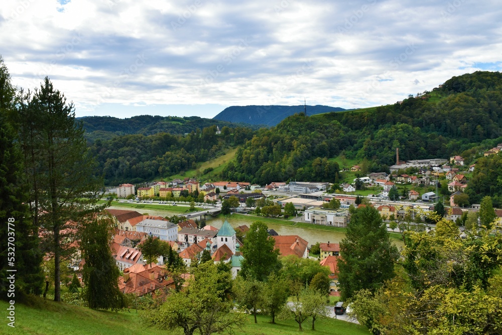 View of the town of Lasko and Savinja river flowing through and forest covered hills above in Stajerska, Slovenia
