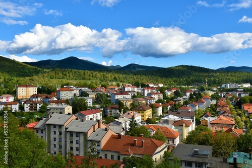 View of town of Postojna in Notranjska, Slovenia with forest covered hills behind photo