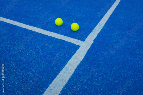 Blue paddle tennis court, two balls close to the line © Vic