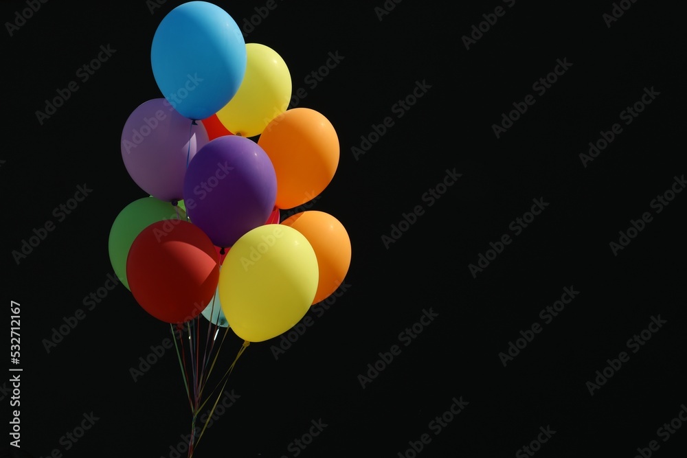 Bunch of colorful balloons on black background. Space for text