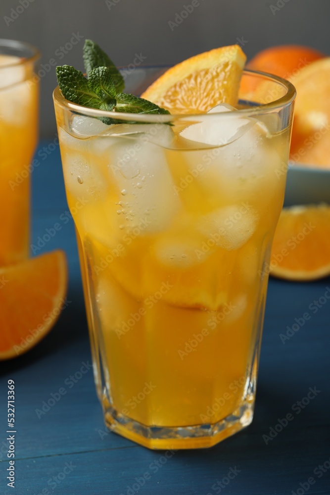 Delicious orange soda water on blue wooden table Delicious orange soda water on blue wooden table