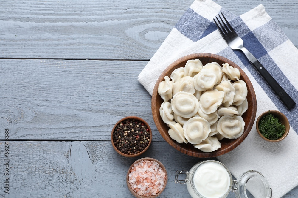 Tasty dumplings in bowl served on grey wooden table, flat lay. Space for text Tasty dumplings in bowl served on grey wooden table, flat lay. Space for text