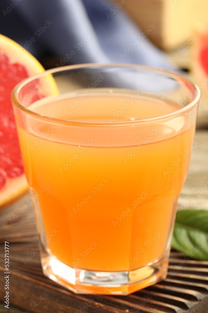 Glass of delicious grapefruit juice on wooden table, closeup Glass of delicious grapefruit juice on wooden table, closeup