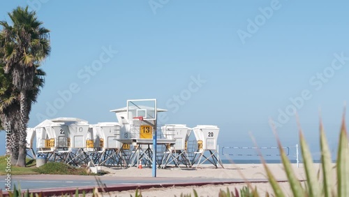 Lifeguard stand and palm tree, life guard tower for surfing on California beach. Summer pacific ocean in USA aesthetic. Iconic rescue baywatch station, coast lifesavers wachtower hut or house by sea.