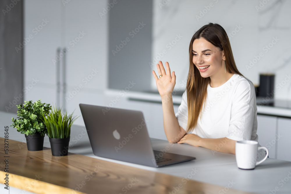 Young woman freelancer sitting at home in the kitchen working remotely Young woman freelancer sitting at home in the kitchen working remotely