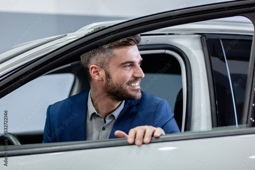 Businessman and his new car that he just bought in showroom.