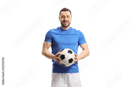 Soccer player holding a ball and looking at camera