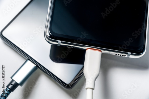 充電中のスマートフォン 白背景 クローズアップイメージ