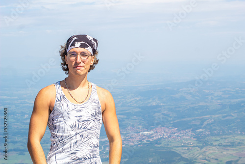 Muscular man standing on top of Mountain Rtanj. Muscular hiker man. With cities and forests under and behind him