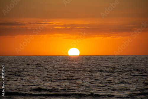 Sun on the horizon, setting over the sea