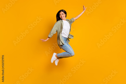 Full body portrait of cheerful gorgeous lady have fun good mood jumping isolated on yellow color background