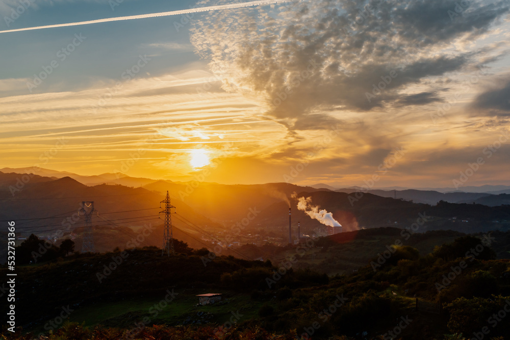 mountainous landscape with thermal power plant emitting steam and fumes at sunset. Industry and sustainability