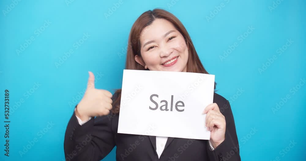 Asian business woman holding paper the text Sale with a happy smile and excited face in sale advertising and copy space Asian business woman holding paper the text Sale with a happy smile and excited face in sale advertising and copy space