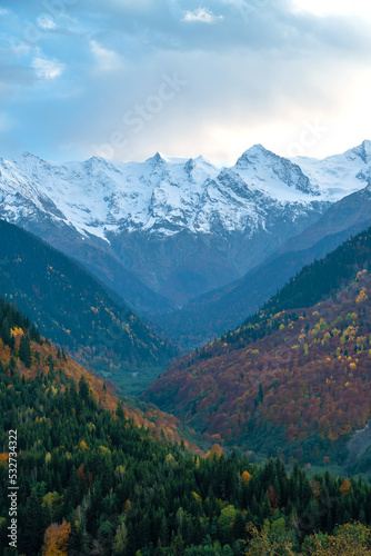 Beautiful mountain autumn landscape with colorful trees, impressive snow peaks. Picturesque landscapes of Svaneti, Georgia. Vertical photo