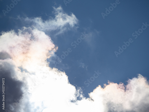 Beautiful landscape with clouds in the sky. Clouds illuminated from behind by the bright sun on a blue sky background
