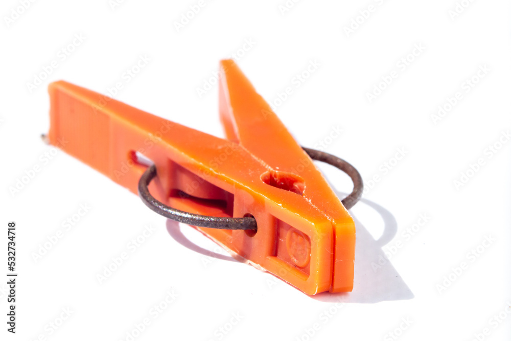 Orange clothespin close-up on a white background. Plastic old clothespin for laundry Orange clothespin close-up on a white background. Plastic old clothespin for laundry