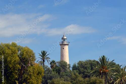 Faro de la playa de Vilanova entre árboles y palmeras