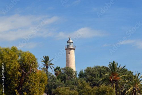 Faro de la playa de Vilanova entre árboles y palmeras