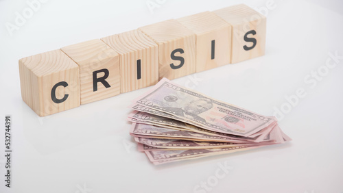 dollar banknotes near wooden cubes with crisis lettering on white background.