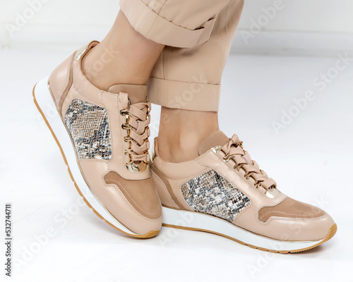 Beige stylish sneakers in a white interior. Trend of the season and photos for advertising