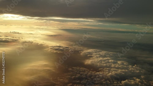 夕日に染まる日没直前の雲上を飛ぶ飛行機からの幻想的な光の風景