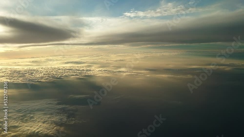 夕日に染まる日没直前の雲上を飛ぶ飛行機からの幻想的な光の風景