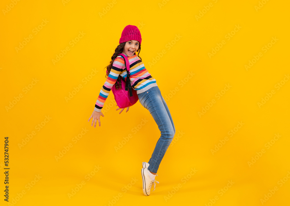 School girl teenager child student with backpack and warn hat, isolated background. Learning and knowledge education concept. Happy teenager, positive and smiling emotions of teen schoolgirl. School girl teenager child student with backpack and warn hat, isolated background. Learning and knowledge education concept. Happy teenager, positive and smiling emotions of teen schoolgirl.