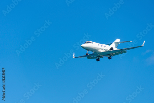 A blurry private jet is landing. Small jet plane in the sky.