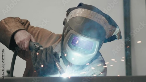 worker welding two pieces of metal in a factory photo