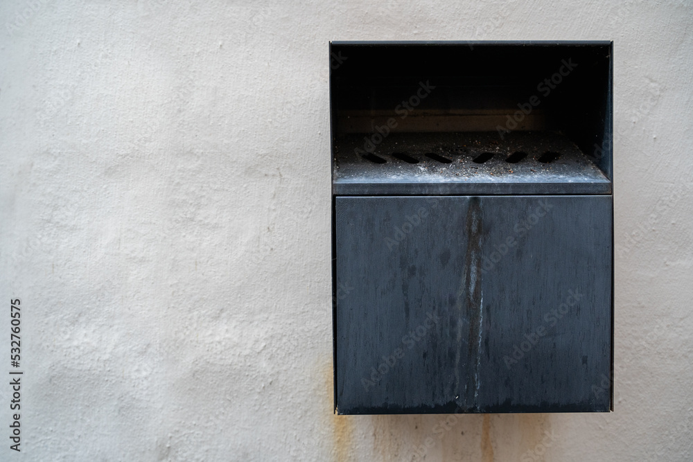 Black metal wall mounted ashtray in public with copy space Black metal wall mounted ashtray in public with copy space