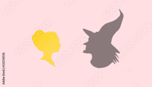 female paper head looking at her witch shadow  creative art halloween concept  pink background  flat lay 