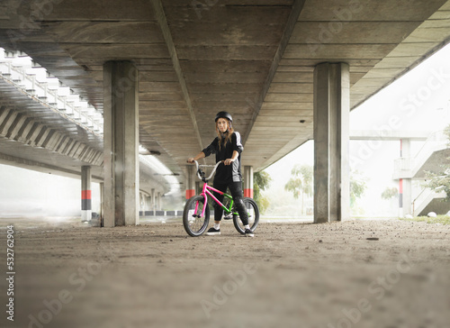 Young urban woman with freestyle bike