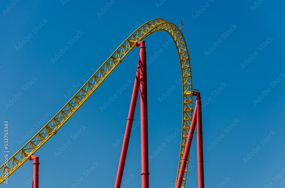 Roller coaster against the blue sky. Amusement park with attractions Roller coaster against the blue sky. Amusement park with attractions