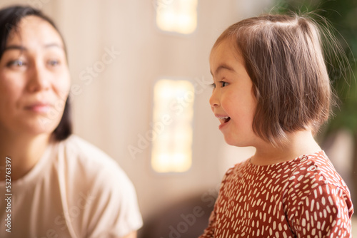 cute child with down syndrome at christmas reads poetry with mom photo